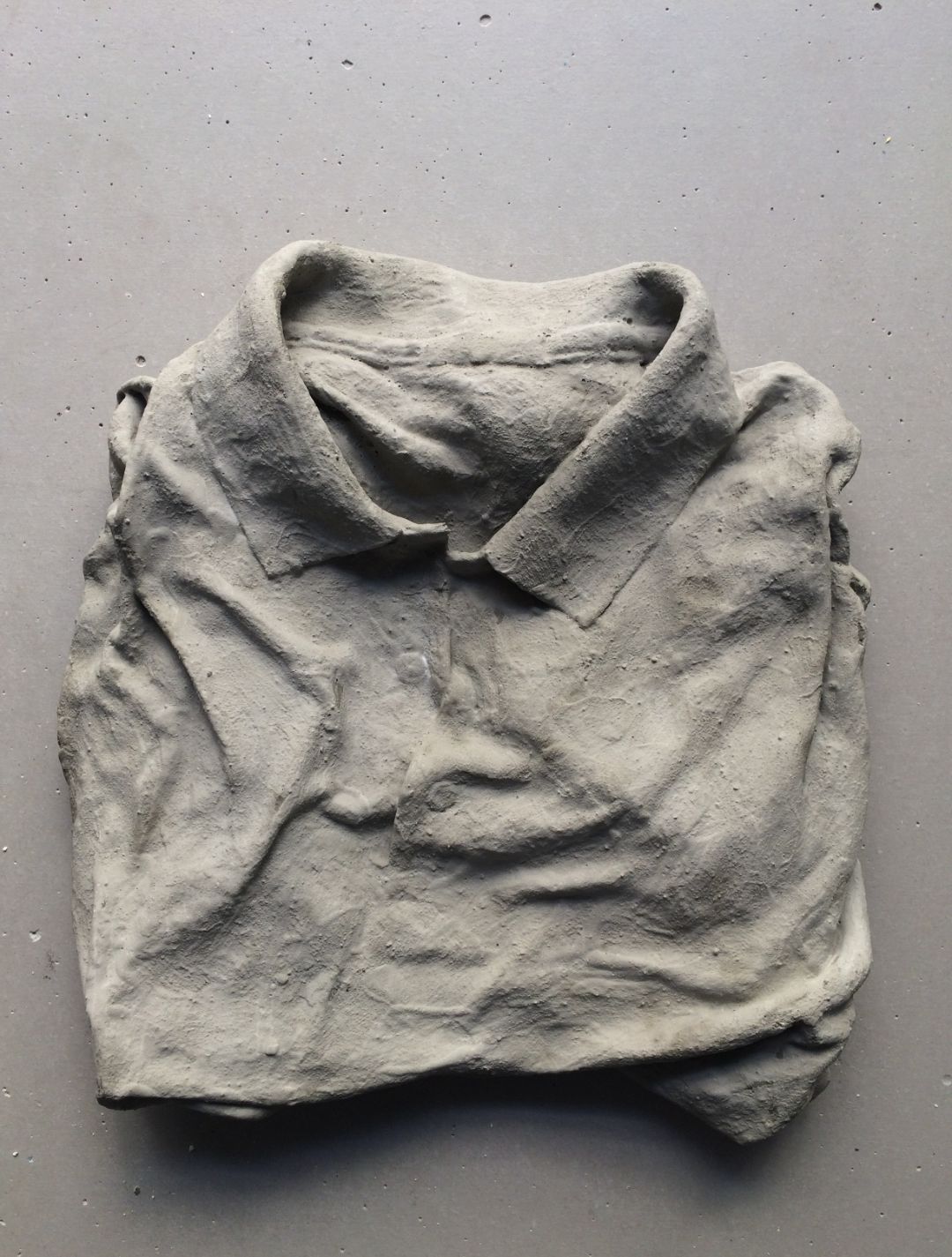 folded collared shirt encased in concrete