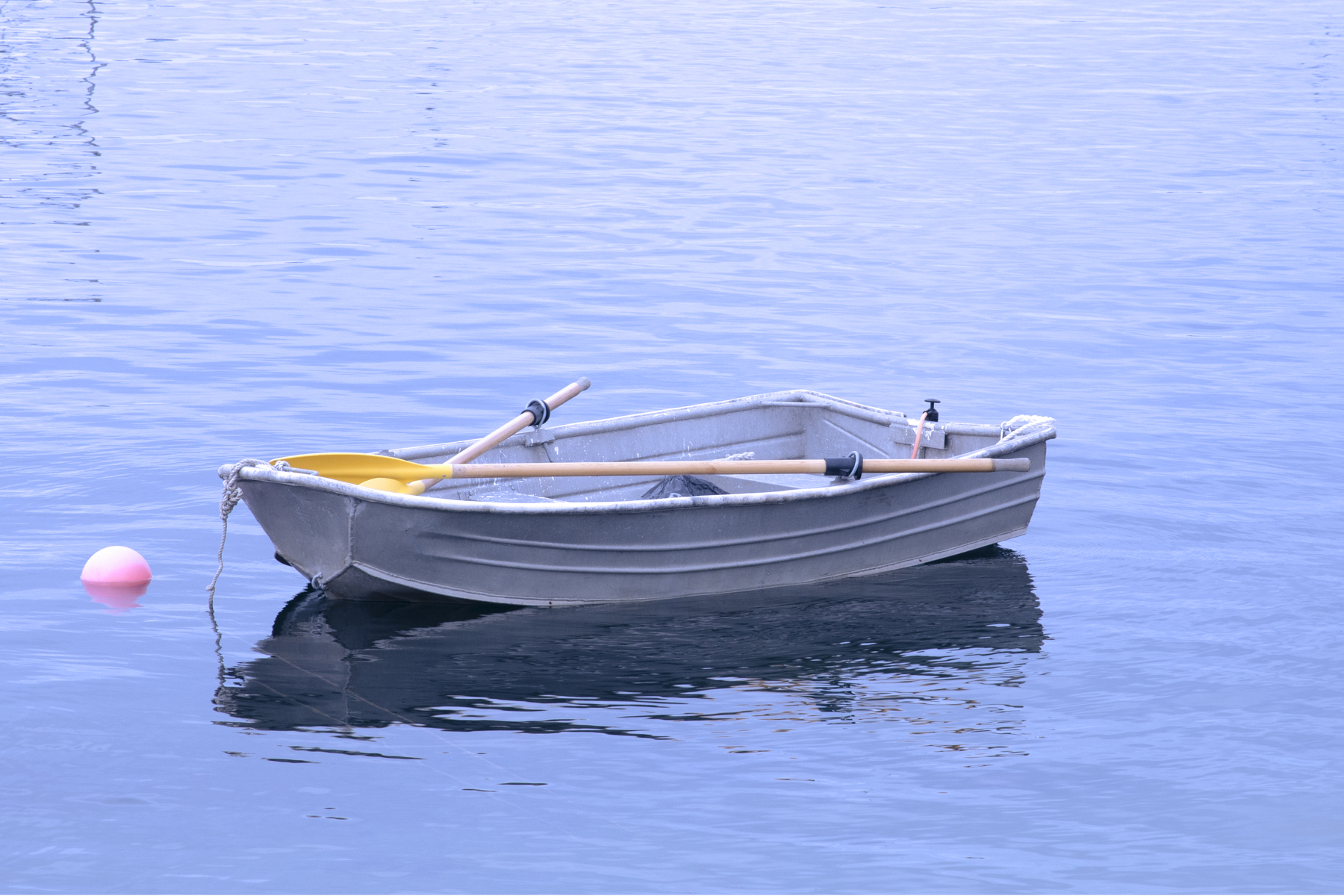 empty rowboat on the water with crossed oars